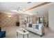 Open-concept living room with a view of the dining area and sunroom, featuring neutral tones and natural light at 8700 Wind Mill Dr, New Port Richey, FL 34655