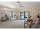 Open living room featuring dining area, leaf-patterned wallpaper, and access to screened porch at 8700 Wind Mill Dr, New Port Richey, FL 34655