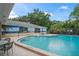 Community pool with beach-themed mural and plenty of space to relax at 8700 Wind Mill Dr, New Port Richey, FL 34655