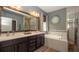 Bathroom with double sinks, granite counters, soaking tub, and walk-in shower at 905 Old Windsor Way, Spring Hill, FL 34609