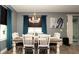 Dining room with wood table, white chairs, chandelier, and curtains at 905 Old Windsor Way, Spring Hill, FL 34609
