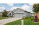 Well-maintained gray home with a two car garage and landscaped yard at 905 Old Windsor Way, Spring Hill, FL 34609