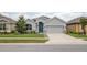 Charming single-story home featuring a well-maintained lawn, blue door, and two-car garage at 905 Old Windsor Way, Spring Hill, FL 34609