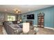 Modern living room with a gray sectional sofa and entertainment center at 905 Old Windsor Way, Spring Hill, FL 34609