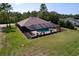 Aerial view of home with large yard and screened-in pool and lanai at 9152 Bunting Rd, Weeki Wachee, FL 34613