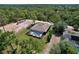 Aerial view showcasing a home with a screened pool and expansive lot in a lush, wooded setting at 9152 Bunting Rd, Weeki Wachee, FL 34613
