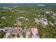 Wide aerial shot capturing a community surrounded by lush forestry and scattered lakes, homes with pools at 9152 Bunting Rd, Weeki Wachee, FL 34613