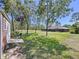 Expansive backyard with lush lawn and screened-in porch, ideal for outdoor relaxation and entertaining at 9152 Bunting Rd, Weeki Wachee, FL 34613