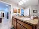 Bathroom with granite countertops, dual sinks, and warm wood cabinetry at 9152 Bunting Rd, Weeki Wachee, FL 34613