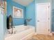Bathroom showcases a garden tub, blue walls, and decorative accents for a serene and spa-like atmosphere at 9152 Bunting Rd, Weeki Wachee, FL 34613