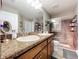 Bathroom with granite counters, dual sinks, a vanity, and a glass-enclosed shower at 9152 Bunting Rd, Weeki Wachee, FL 34613