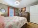 Bright bedroom with a coral patterned quilt, wood floors, and tropical artwork at 9152 Bunting Rd, Weeki Wachee, FL 34613