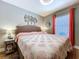 Cozy bedroom featuring neutral walls, wood floors, and a decorative coral quilt on the bed at 9152 Bunting Rd, Weeki Wachee, FL 34613