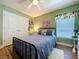 Cozy bedroom with a black metal bed frame, wood flooring, and natural light at 9152 Bunting Rd, Weeki Wachee, FL 34613