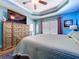 Bright bedroom with blue walls, tray ceilings, and a large dresser at 9152 Bunting Rd, Weeki Wachee, FL 34613