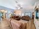 Comfortable living room featuring ample seating, hardwood floors, ceiling fan, and view to kitchen at 9152 Bunting Rd, Weeki Wachee, FL 34613