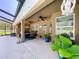 Spacious covered patio with ceiling fans, a dining area, and lush greenery at 9152 Bunting Rd, Weeki Wachee, FL 34613