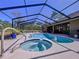 Stunning screened-in pool area features a hot tub, a large in-ground pool, and plenty of room for entertaining at 9152 Bunting Rd, Weeki Wachee, FL 34613