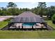Aerial view of a screened-in pool and spa area, surrounded by lush landscaping at 9152 Bunting Rd, Weeki Wachee, FL 34613