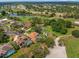 Aerial view of homes in a golf course community with lake, lush landscaping, and mature trees at 9161 Southern Comfort Ct, Weeki Wachee, FL 34613