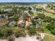 Aerial view of a well-manicured neighborhood with a golf course and a sparkling lake in the background at 9161 Southern Comfort Ct, Weeki Wachee, FL 34613