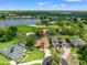Aerial view of home with tile roof, surrounded by lush greenery, a pond, and a golf course at 9161 Southern Comfort Ct, Weeki Wachee, FL 34613