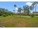 A spacious backyard with lush grass, mature landscaping and screened-in porch features views of the home at 9161 Southern Comfort Ct, Weeki Wachee, FL 34613
