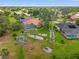 Landscaped backyard featuring lush green lawn and elegant landscaping, a pool, and a screened enclosure at 9161 Southern Comfort Ct, Weeki Wachee, FL 34613
