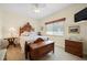 Cozy bedroom features a ceiling fan, a wooden chest, and comfortable furnishings at 9161 Southern Comfort Ct, Weeki Wachee, FL 34613