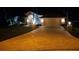 Night view of a well-maintained home with a spacious driveway, garage, and manicured lawn at 9161 Southern Comfort Ct, Weeki Wachee, FL 34613