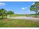 Expansive golf course view with lush green grass, trees, and a sand bunker under a clear blue sky at 9161 Southern Comfort Ct, Weeki Wachee, FL 34613
