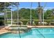 This shot of a pool features a hot tub with brick-look tile and nice landscaping surrounding the pool area at 9161 Southern Comfort Ct, Weeki Wachee, FL 34613