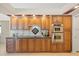 Kitchen showcasing wood cabinetry, tile backsplash, and stainless steel appliances at 9161 Southern Comfort Ct, Weeki Wachee, FL 34613
