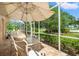 A patio with screened-in enclosure features a table, chairs, and seating area overlooking lush landscaping at 9161 Southern Comfort Ct, Weeki Wachee, FL 34613