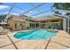 A backyard features a large in-ground pool, hot tub, screened-in enclosure and outdoor bar/kitchen at 9161 Southern Comfort Ct, Weeki Wachee, FL 34613