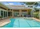 The outdoor space boasts a large in-ground swimming pool, hot tub and screened-in enclosure with an outdoor kitchen at 9161 Southern Comfort Ct, Weeki Wachee, FL 34613