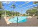 A screened-in pool area with a hot tub is surrounded by lush landscaping and lots of space for entertaining at 9161 Southern Comfort Ct, Weeki Wachee, FL 34613
