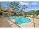 An in-ground pool features an attached hot tub and screened-in enclosure with an outdoor kitchen visible at 9161 Southern Comfort Ct, Weeki Wachee, FL 34613