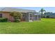 A screened-in back porch with a lush green lawn extending to a palm tree at 9622 Brassie Ct # 9, New Port Richey, FL 34655