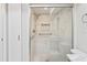 Renovated bathroom with a new glass shower, a built-in niche, and grab bars at 9622 Brassie Ct # 9, New Port Richey, FL 34655