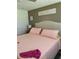 Bedroom with bed dressed in pink, decorative sign, and light-colored walls at 9622 Brassie Ct # 9, New Port Richey, FL 34655
