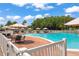 Community pool with lounge chairs, tables, and umbrellas for relaxation and enjoyment at 9622 Brassie Ct # 9, New Port Richey, FL 34655