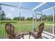 Covered lanai with seating overlooking a lush green space and golf course at 9622 Brassie Ct # 9, New Port Richey, FL 34655