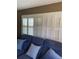 Living room featuring white plantation shutters over a comfortable blue sofa at 9622 Brassie Ct # 9, New Port Richey, FL 34655