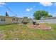 Spacious backyard with lush lawn, grilling area, fire pit, and white privacy fence at 9891 52Nd N St, Pinellas Park, FL 33782