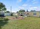 Expansive backyard with green grass, patio area, grill, fire pit, and white fence at 9891 52Nd N St, Pinellas Park, FL 33782