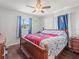 Cozy bedroom featuring a wood-framed bed, hardwood floors and natural light from the window at 9891 52Nd N St, Pinellas Park, FL 33782