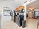 Functional kitchen with black appliances and wooden cabinets, adjacent to a laundry area at 9891 52Nd N St, Pinellas Park, FL 33782