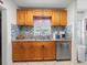 Kitchen featuring wooden cabinets, granite countertop, and a stainless steel dishwasher at 9891 52Nd N St, Pinellas Park, FL 33782