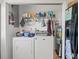 Functional laundry area with washer, dryer, and overhead shelving for storage at 9891 52Nd N St, Pinellas Park, FL 33782